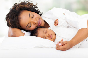 cute african mother and baby sleeping in bed